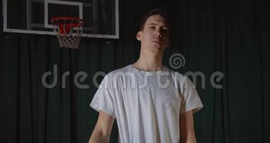 流行的高加索人篮球运动员在背景上打篮球的肖像严肃自信的样子白色T